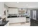 Bright kitchen with white cabinets, dark countertops, and stainless steel dishwasher, complemented by modern lighting at 2714 Witley Ave, Palm Harbor, FL 34685