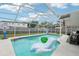Inviting screened-in pool with lounge float, basketball hoop, and fenced backyard at 2714 Witley Ave, Palm Harbor, FL 34685