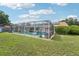 Backyard view with a screened-in pool, lounge chairs, and a well-manicured lawn at 2714 Witley Ave, Palm Harbor, FL 34685