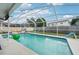 Relaxing screened-in pool area, with a slide, and colorful floats for summer fun at 2714 Witley Ave, Palm Harbor, FL 34685