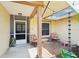 Cozy covered porch with a seating area, decorative rain chain, and view of front entrance at 2714 Witley Ave, Palm Harbor, FL 34685