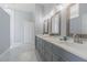 Bright bathroom with marble floors, dual sink vanity, framed mirrors, and a glass shower at 2957 Hickory Grove Dr, Valrico, FL 33596