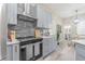 Modern kitchen features stainless steel appliances, gray cabinets, and sleek tile backsplash at 2957 Hickory Grove Dr, Valrico, FL 33596