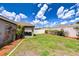 Large, well-maintained backyard with lush grass, a white fence, and a covered patio area at 31349 Philmar Ln, Wesley Chapel, FL 33543