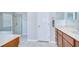 Bright bathroom featuring a glass shower enclosure and vanity with marble countertop at 31349 Philmar Ln, Wesley Chapel, FL 33543