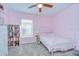 Charming bedroom with pink walls, carpet, and window with blinds at 31349 Philmar Ln, Wesley Chapel, FL 33543