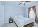 Cozy bedroom with neutral carpet, large window with blinds, and a ceiling fan at 31349 Philmar Ln, Wesley Chapel, FL 33543