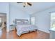 Spacious bedroom with wood floors, large bed, and an open doorway at 31349 Philmar Ln, Wesley Chapel, FL 33543