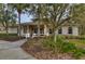 Community clubhouse featuring tan siding, white trim, a covered porch, and landscaping at 31349 Philmar Ln, Wesley Chapel, FL 33543