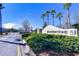 Community entrance with a sign reading 'Heatherstone,' landscaped greenery, and palm trees at 31349 Philmar Ln, Wesley Chapel, FL 33543