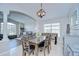 Formal dining room with wood table and chairs, view into the living room, and modern light fixture at 31349 Philmar Ln, Wesley Chapel, FL 33543