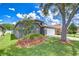 Landscaped single-story home featuring a well-maintained lawn, trimmed shrubbery, and a two-car garage at 31349 Philmar Ln, Wesley Chapel, FL 33543