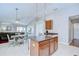 Open kitchen with an island, granite counters, seating, and a view into the living room at 31349 Philmar Ln, Wesley Chapel, FL 33543