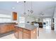 Open-concept kitchen with stainless appliances, island, and view into living room with sliding doors at 31349 Philmar Ln, Wesley Chapel, FL 33543