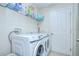 Functional laundry room with modern washer and dryer appliances and storage shelves at 31349 Philmar Ln, Wesley Chapel, FL 33543