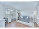 Bright living room with vaulted ceilings, desk and sleeper sofa next to large window at 31349 Philmar Ln, Wesley Chapel, FL 33543