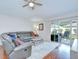 Cozy living room with a ceiling fan, hardwood flooring, and sliding glass doors to the outdoor patio at 31349 Philmar Ln, Wesley Chapel, FL 33543