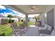 Covered patio area with outdoor seating, ceiling fan, and views of the backyard at 31349 Philmar Ln, Wesley Chapel, FL 33543