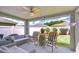 Covered patio featuring comfortable seating and a ceiling fan, overlooking a well-maintained backyard at 31349 Philmar Ln, Wesley Chapel, FL 33543