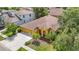 Aerial view of a well-maintained home with a lush lawn, mature trees, and an expansive driveway at 3824 Duke Firth St, Land O Lakes, FL 34638