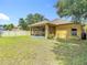Large backyard showing the yellow house exterior and screened in patio with a privacy fence at 3824 Duke Firth St, Land O Lakes, FL 34638