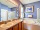 Bright bathroom features a double vanity, soaking tub, and separate glass-enclosed shower at 3824 Duke Firth St, Land O Lakes, FL 34638