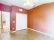 Empty bedroom featuring a double closet, terra cotta colored walls, and neutral flooring at 3824 Duke Firth St, Land O Lakes, FL 34638