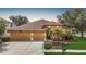 Charming single-story home with a two-car garage, manicured lawn, and lush tropical landscaping at 3824 Duke Firth St, Land O Lakes, FL 34638
