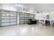 Spacious three car garage with white epoxy flooring and three car doors, plus a small workstation at 3824 Duke Firth St, Land O Lakes, FL 34638
