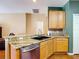 Well-equipped kitchen with a double sink, granite counters, wood cabinets, and stainless steel dishwasher at 3824 Duke Firth St, Land O Lakes, FL 34638