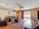 Living room features hardwood floors, ceiling fan, and sliding doors to a screened patio at 3824 Duke Firth St, Land O Lakes, FL 34638