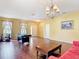 Bright living room with hardwood floors, pool table, natural light, and a stylish chandelier at 3824 Duke Firth St, Land O Lakes, FL 34638