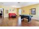 Spacious living room with gleaming hardwood floors, ample lighting, and a classic pool table at 3824 Duke Firth St, Land O Lakes, FL 34638