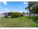 Spacious backyard with tropical foliage, lush grass, and a screened patio area for outdoor living at 3839 18Th N Ave, St Petersburg, FL 33713