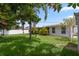 This backyard features mature trees, a well-manicured lawn, and a glimpse of the home's exterior at 3839 18Th N Ave, St Petersburg, FL 33713
