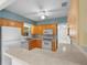 A kitchen with tan cabinets, white appliances, and modern countertops with seamless flow into the hallway at 3839 18Th N Ave, St Petersburg, FL 33713