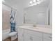 Bright bathroom featuring a white vanity, decorative shower curtain, and tile flooring at 4020 Via Sienna Cir, Sarasota, FL 34243