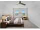 This bedroom features natural light, a ceiling fan, and neutral decor at 4020 Via Sienna Cir, Sarasota, FL 34243