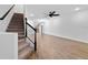 Open-concept living area with a staircase featuring hardwood floors, white walls, and ceiling fan at 4020 Via Sienna Cir, Sarasota, FL 34243