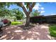 Paver patio with mature tree in a fenced backyard and leading to the screened-in porch of this lovely home at 4124 Herrick Ln, Sarasota, FL 34241