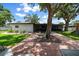 Paver patio with mature tree in a fenced backyard leading to screened-in porch in this lovely home at 4124 Herrick Ln, Sarasota, FL 34241