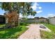 Fenced backyard with mature trees, a play structure, and a sports court at 4124 Herrick Ln, Sarasota, FL 34241