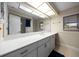 Bathroom boasting an expansive vanity with modern cabinets, a large mirror, and natural lighting at 4124 Herrick Ln, Sarasota, FL 34241