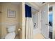 Bathroom featuring a toilet and shower/tub combination with blue accent curtains and a modern design at 4124 Herrick Ln, Sarasota, FL 34241