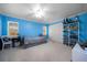 Bedroom with bright blue walls, carpet, natural light from three windows, and shelving for decor at 4124 Herrick Ln, Sarasota, FL 34241