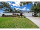 Charming single-story home featuring a manicured lawn, mature trees, and a two-car garage at 4124 Herrick Ln, Sarasota, FL 34241