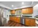 Bright kitchen with wood cabinetry, stainless steel dishwasher, and a window above the sink at 4124 Herrick Ln, Sarasota, FL 34241