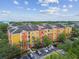 An aerial view of condos with bright exterior paint, well-maintained landscaping, and parking at 4207 S Dale Mabry Hwy # 2105, Tampa, FL 33611