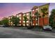 Condominium with colorful exterior paint, reserved parking, and mature landscaping at twilight at 4207 S Dale Mabry Hwy # 2105, Tampa, FL 33611