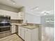 Modern kitchen featuring stainless steel appliances, granite countertops, and ample cabinet space with a view into the living area at 4207 S Dale Mabry Hwy # 2105, Tampa, FL 33611